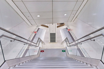现代清洁白色地铁站楼梯领先的跟踪红色的绿色箭头标记