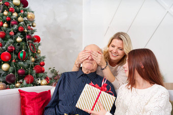 孙女给礼物祖父快乐高级男人。拥抱（外）孙女接收礼物圣诞节首页