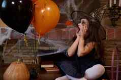 惊讶孩子女孩女巫向导他橙色黑色的气球坐着cobweb-covered壁炉