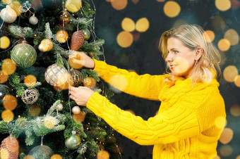 女人装修美丽的圣诞节树首页特写镜头圣诞节假期人概念