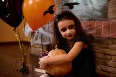 女巫坐在壁炉蜘蛛网橙色黑色的气球拥抱万圣节南瓜南瓜灯
