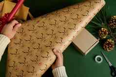 前视图女人的手卷装饰包装礼物纸鹿模式包装礼物圣诞节准备工作