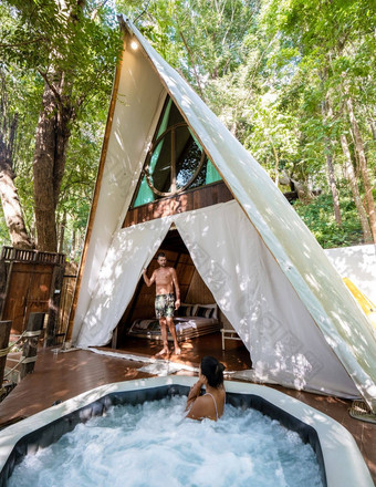 夫妇男人。女人帐篷jaccuzzi丛林雨森林奢侈品豪华露营