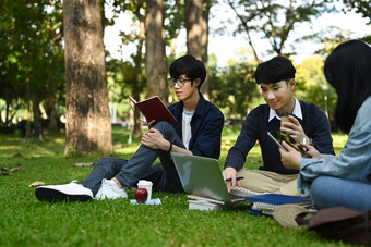 集团大学学生会说话的放松校园草坪上工作移动PC教育生活方式概念