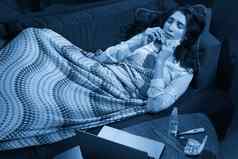 年轻的女人沙发覆盖毯子冻结吹运行鼻子发热抓住了生病的女孩流感症状流感病毒概念