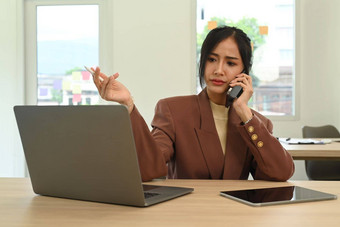 女商人电话谈话客户<strong>端</strong>移动<strong>PC</strong>电脑办公室桌子上