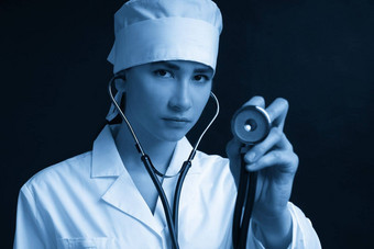 裁剪视图年轻的女医生持有听诊器挂脖子工作室拍摄黑色的背景复制空间