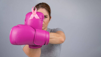 高加索人女人粉红色的拳击手套粉红色的丝带胸部灰色的背景战斗<strong>乳房癌症</strong>