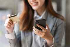 年轻的人信贷卡移动电话在线购物电子商务概念
