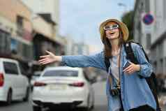 高加索人女旅行者提高手调用出租车忙城市街旅游运输概念