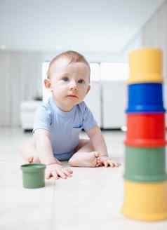 颜色可爱的婴儿男孩玩玩具生活房间地板上