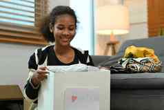 年轻的女人持有盒子衣服捐赠标签慈善机构捐赠重用回收概念