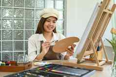 愉快的女艺术家调色板刷绘画画架艺术工作室教育爱好艺术概念