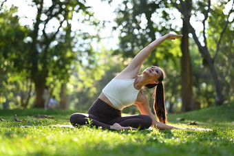 愉快的千禧女人实践瑜伽户外早....健康撤退健康的生活方式概念