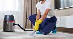 男人。清洁地毯生活房间真空更清洁的首页清洁服务概念