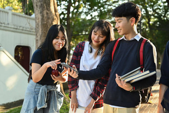 集团亚洲学生移动电话走在户外大学校园青年社区概念