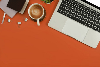 平躺移动PC电脑杯咖啡记事本盆栽植物橙色背景前视图复制空间