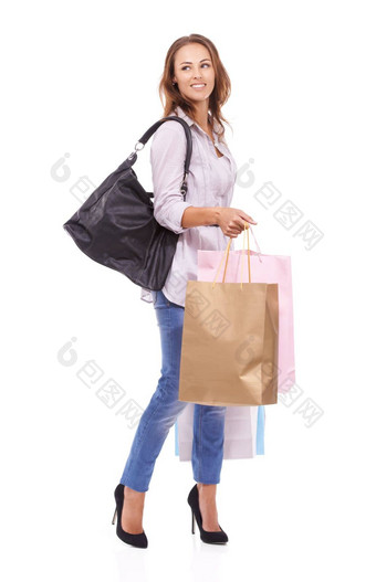 步进购物微笑年轻的女人持有店里购物袋孤立的白色