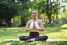 健康的美丽的女人练习瑜伽冥想关闭眼睛健康生活方式正念冥想概念