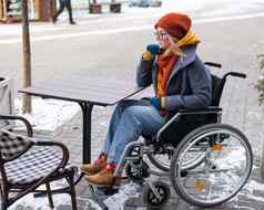 高加索人女人轮椅坐着户外咖啡馆表格
