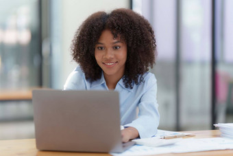 年轻的非洲美国女商人工作移动PC办公室焦点屏幕移动PC阅<strong>读</strong>有趣的<strong>文章</strong>在线金融