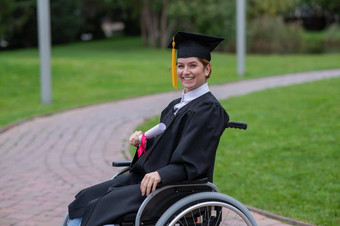 快乐高加索人女人轮椅持有文凭在户外