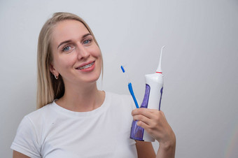 微笑高加索人女人牙套牙齿持有冲洗器牙刷