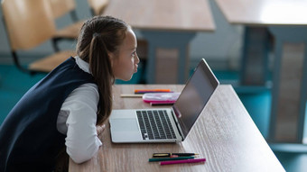高加索人女孩沟通视频沟通移动PC坐着学校桌子上