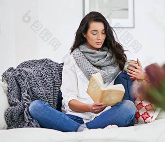 喝咖啡读<strong>好书</strong>年轻的女人阅读书坐着生活房间