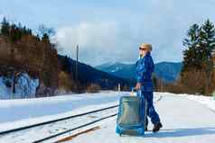 女人拉重行李雪火车站旅行火车冬天