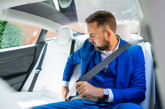 高加索人男人。蓝色的西装系座位带回来座位车业务类乘客
