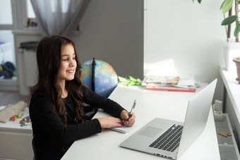微笑年轻的青少年女学生涉及到视频网络相机调用电脑老师听遥远的教育讲座在线教室在家教育概念