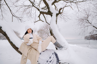 美丽的女孩米色开襟羊毛衫白色他享受<strong>喝茶</strong>雪<strong>冬天</strong>森林湖