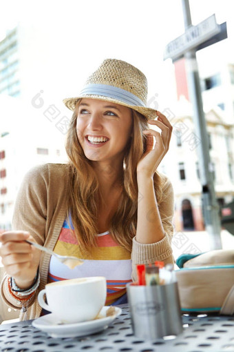 最喜欢的咖啡商店年轻的女人激动人心的cappucino坐着人行道上咖啡馆城市
