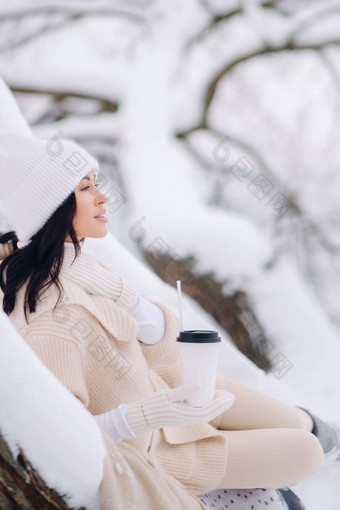 美丽的女孩米色开襟羊毛衫白色他享受喝茶雪冬天森林湖