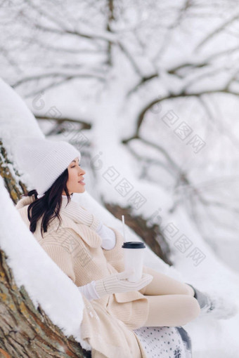 美丽的女孩米色开襟羊毛衫白色他享受<strong>喝茶</strong>雪<strong>冬天</strong>森林湖