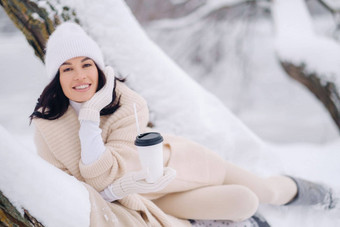 美丽的女孩米色开襟羊毛衫白色他享受喝茶雪冬天森林湖