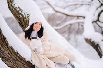 美丽的女孩米色开襟<strong>羊毛</strong>衫白色他享受喝茶雪冬天森林湖