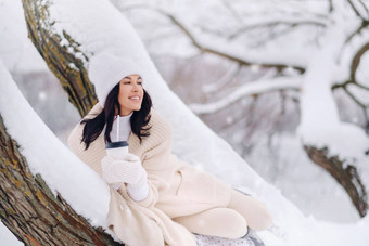 美丽的女孩米色开襟羊毛衫白色他享受喝茶雪冬天森林湖