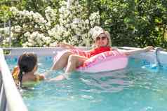 有趣的周末在户外肖像快乐活跃的妈妈。孩子泳衣游泳池放松
