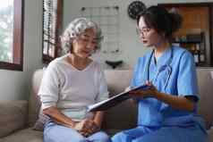 亚洲年轻的护士有爱心的病人上了年纪的首页护理首页概念