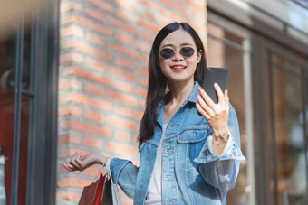 亚洲时尚女人走购物购物中心购物袋闪光出售促销活动