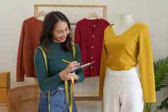 亚洲女人时尚设计师布裁缝有创意的工作集合快乐在线商店老板准备订单航运