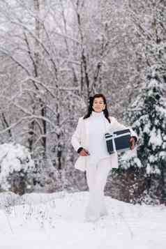 时尚的女人白色西装一年的礼物手冬天森林女孩自然雪森林礼物盒子