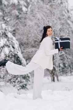 时尚的女人白色西装一年的礼物手冬天森林女孩自然雪森林礼物盒子