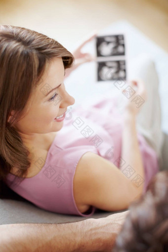 享受超声波准父母美丽的怀孕了女人超声波扫描丈夫俯视图