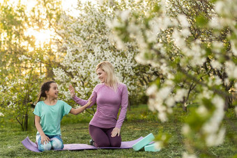 年轻的女人女儿运动统一的瑜伽房子花园