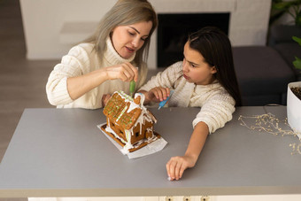 妈妈。女儿使姜饼饼干房子装修首页圣诞节概念