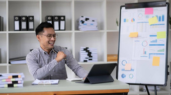 有吸引力的亚洲泰国男人。工作屏幕电脑聪明的平板电脑表格桌子上办公室自由数据分析师数据科学科学家业务
