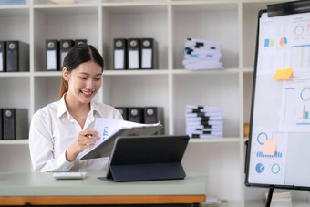 亚洲女商人集中文书工作准备报告分析工作使文书工作工作电脑软件在线办公室